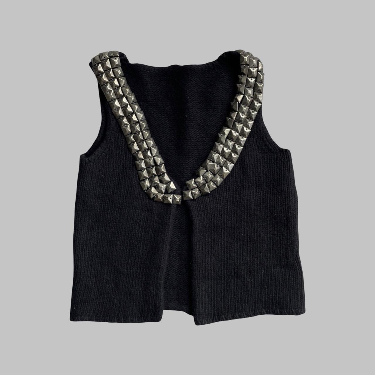 Sleeveless knit black vest with silver studs.