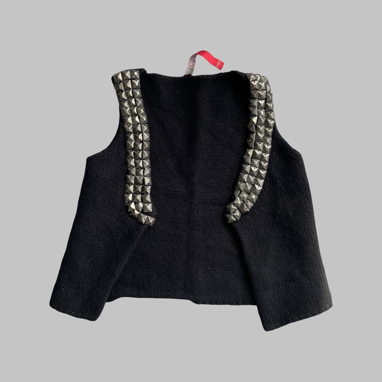 Sleeveless knit black vest with silver studs.