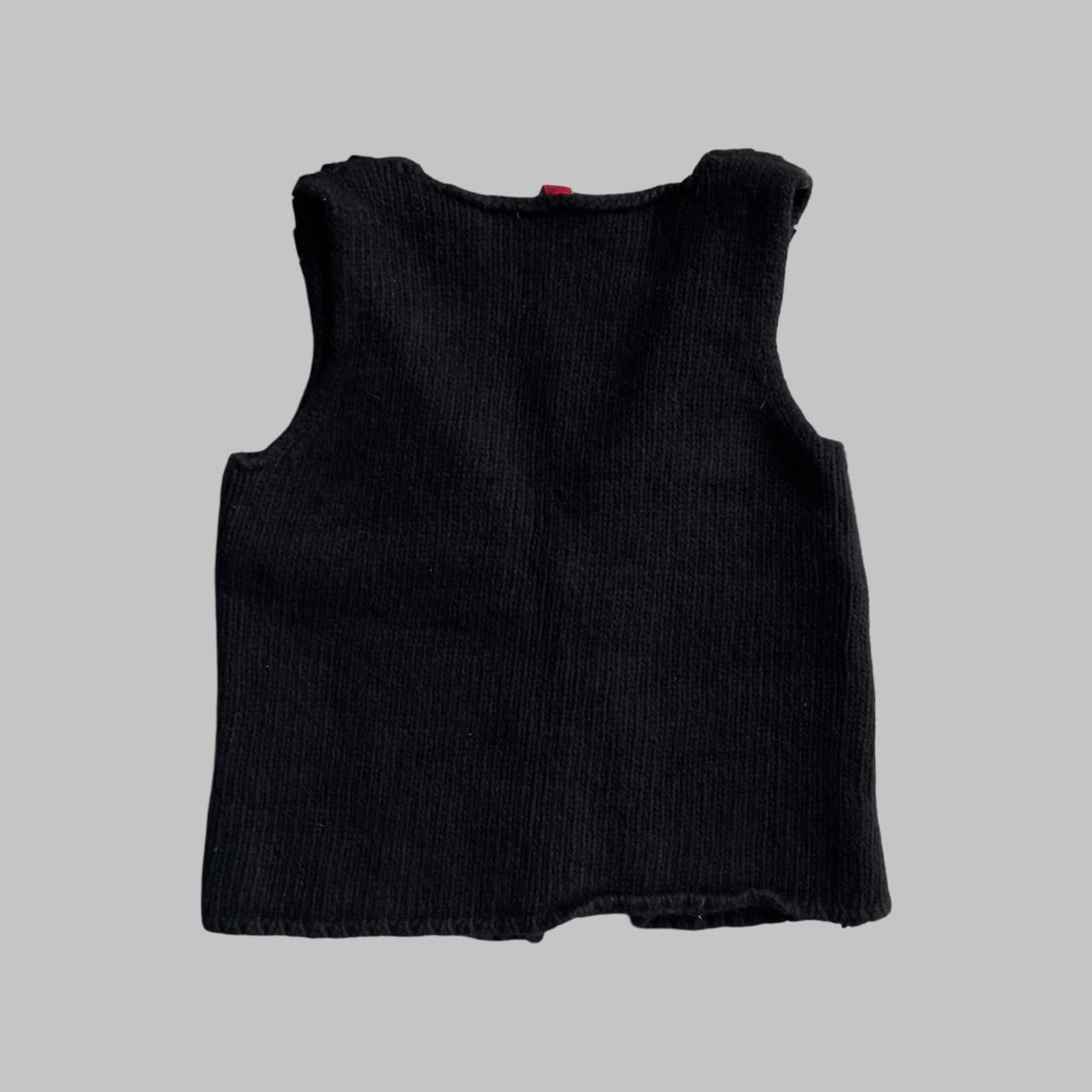 Sleeveless knit black vest with silver studs.
